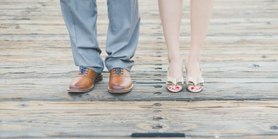 男人穿着棕色皮革牛津鞋旁边女人穿黄金露趾凉鞋
